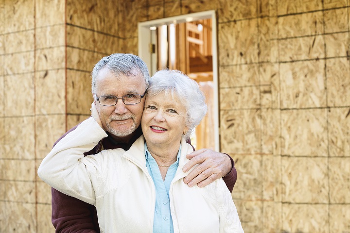 Image of an older couple in front of a house